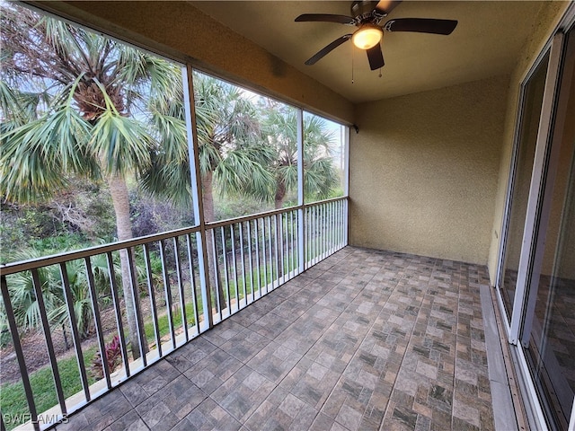 unfurnished sunroom with ceiling fan