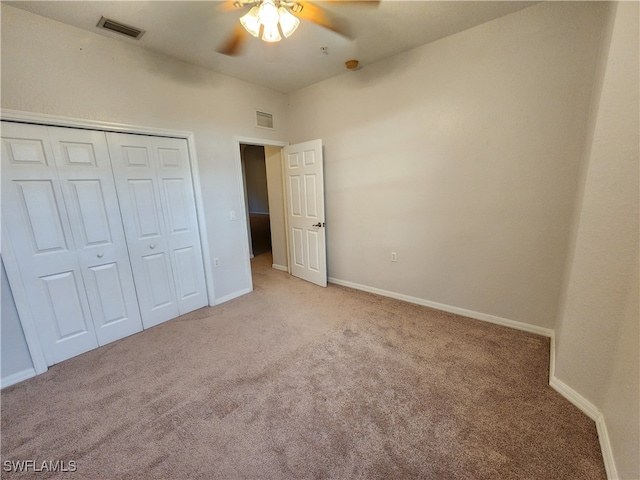 unfurnished bedroom featuring ceiling fan, a closet, and light colored carpet