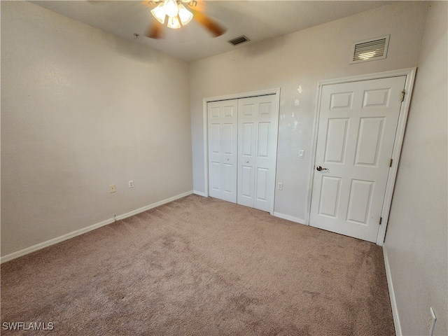 unfurnished bedroom with a closet, carpet, and ceiling fan