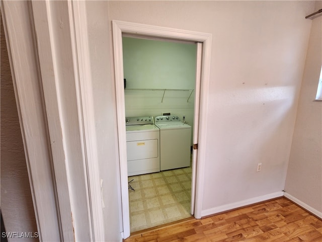 clothes washing area with light wood-type flooring and washer and clothes dryer