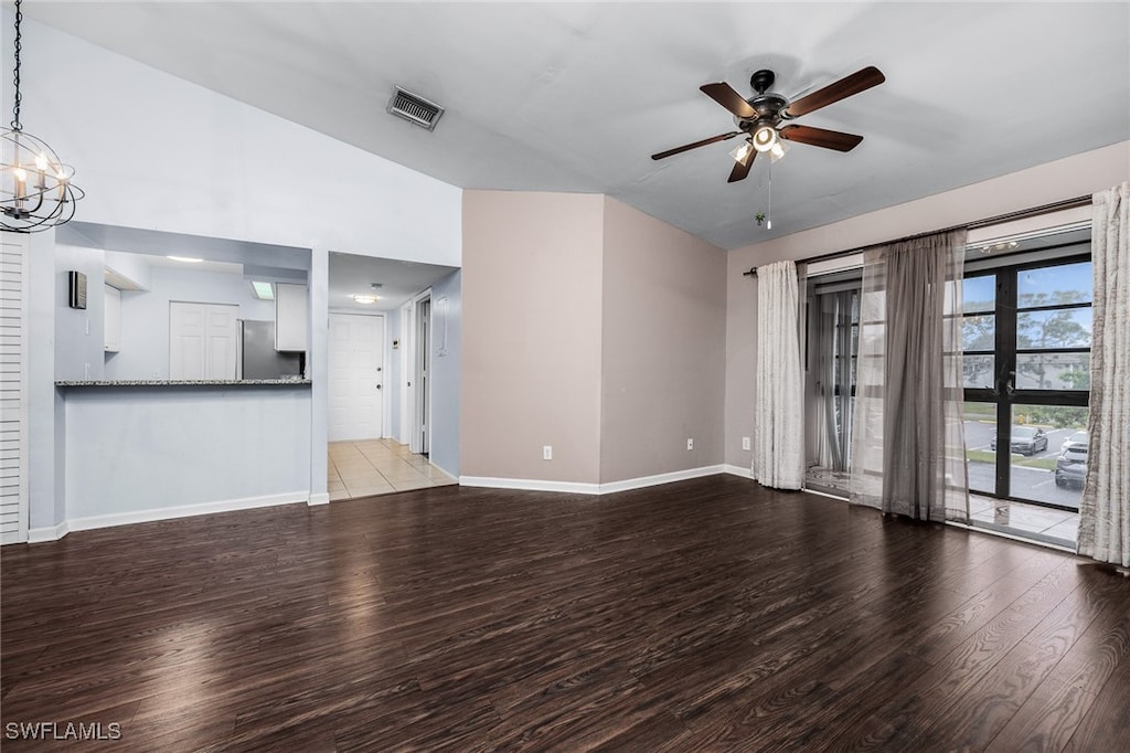 unfurnished living room with ceiling fan with notable chandelier and light wood-type flooring