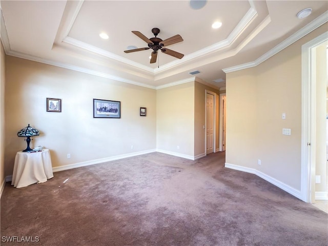 spare room featuring ceiling fan, carpet floors, crown molding, and a tray ceiling