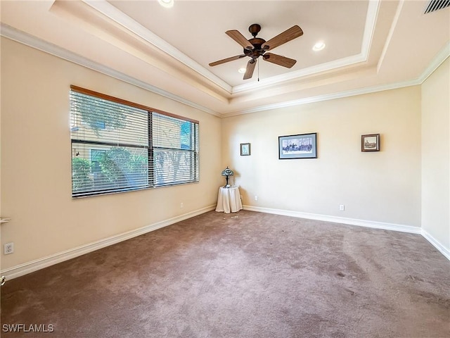 carpeted spare room featuring ceiling fan, ornamental molding, and a tray ceiling