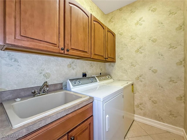 clothes washing area with sink, light tile patterned floors, cabinets, and independent washer and dryer