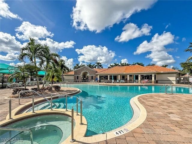 view of swimming pool featuring a patio area and a hot tub