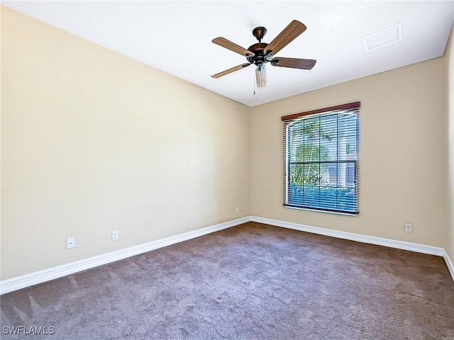 spare room with dark colored carpet and ceiling fan