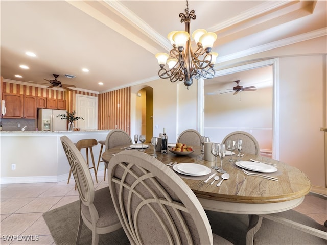 dining room with arched walkways, recessed lighting, a raised ceiling, ornamental molding, and light tile patterned flooring