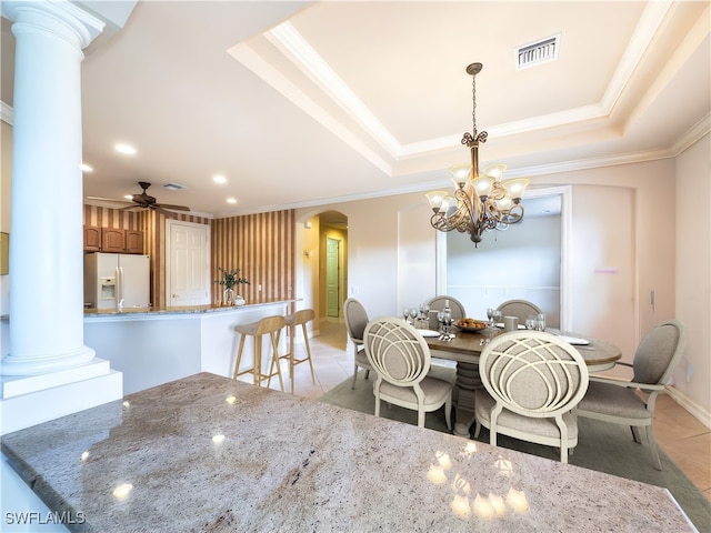 dining space featuring a raised ceiling, ornate columns, crown molding, and light tile patterned floors