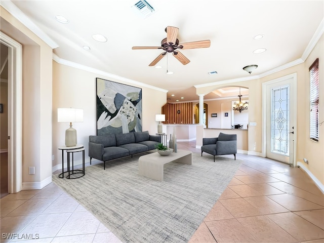 living room with ceiling fan with notable chandelier, light tile patterned flooring, and ornamental molding