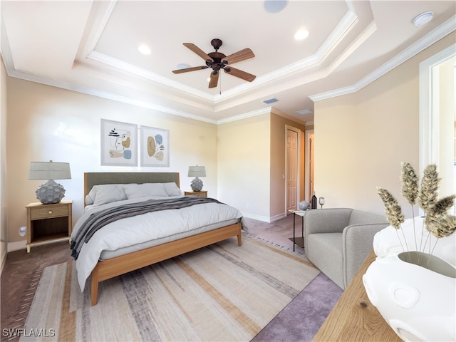 bedroom featuring ceiling fan, ornamental molding, and a tray ceiling