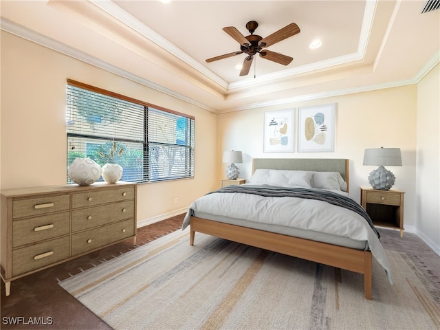 bedroom with baseboards, visible vents, a raised ceiling, crown molding, and dark carpet