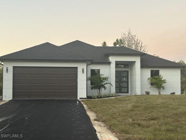 view of front of property featuring a lawn and a garage