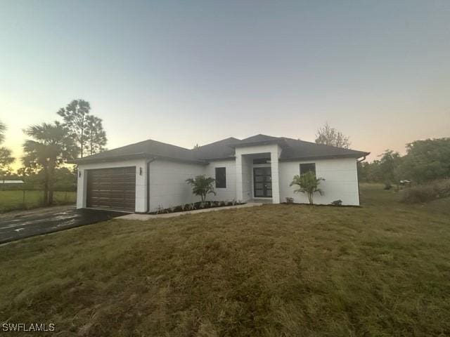 view of front of home featuring a lawn and a garage