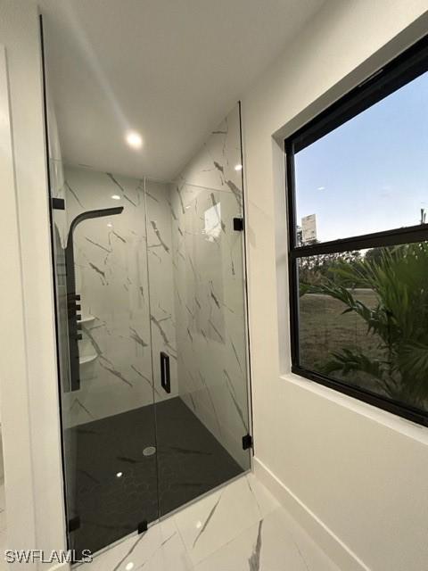 bathroom featuring a shower with door