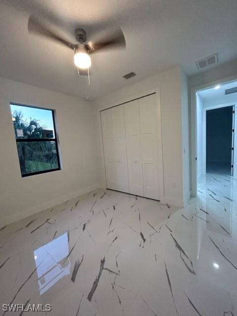 unfurnished bedroom with a textured ceiling, a closet, and ceiling fan