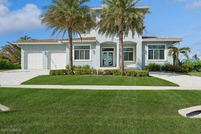 mediterranean / spanish-style home with a garage and a front lawn