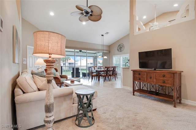 carpeted living room with ceiling fan and high vaulted ceiling