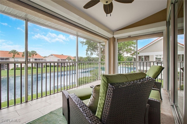 sunroom featuring ceiling fan, a water view, and vaulted ceiling