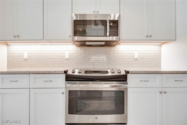 kitchen with light stone counters, white cabinetry, and stainless steel appliances