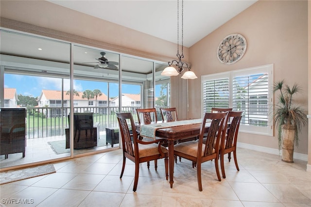 dining space featuring ceiling fan with notable chandelier, lofted ceiling, and light tile patterned floors