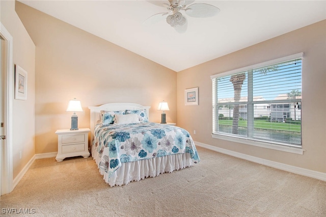 bedroom featuring light colored carpet, vaulted ceiling, and ceiling fan