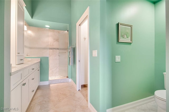 bathroom featuring a tile shower, tile patterned floors, vanity, and toilet