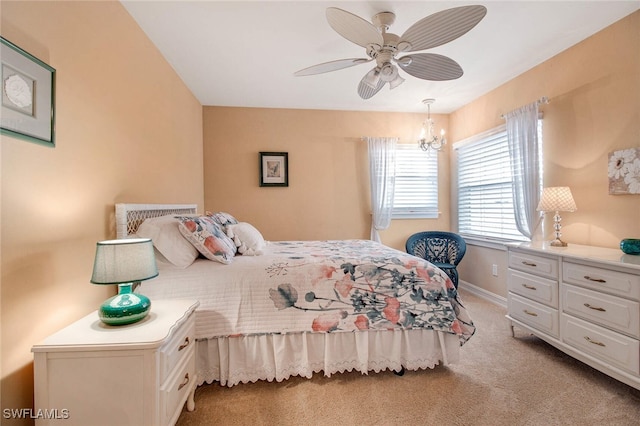 carpeted bedroom with ceiling fan with notable chandelier