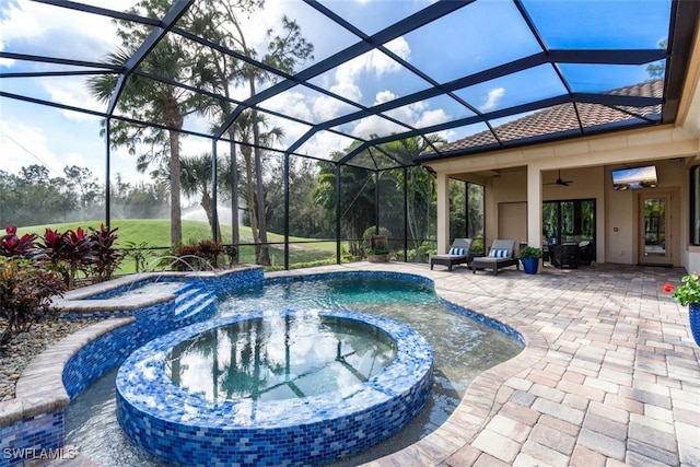 view of pool featuring pool water feature, an in ground hot tub, ceiling fan, a lanai, and a patio area