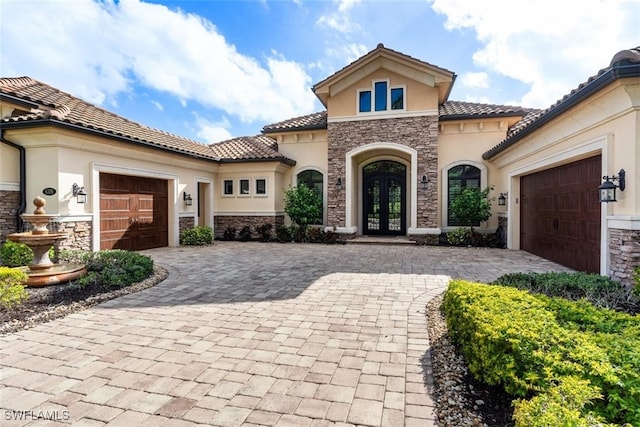 mediterranean / spanish house with french doors and a garage