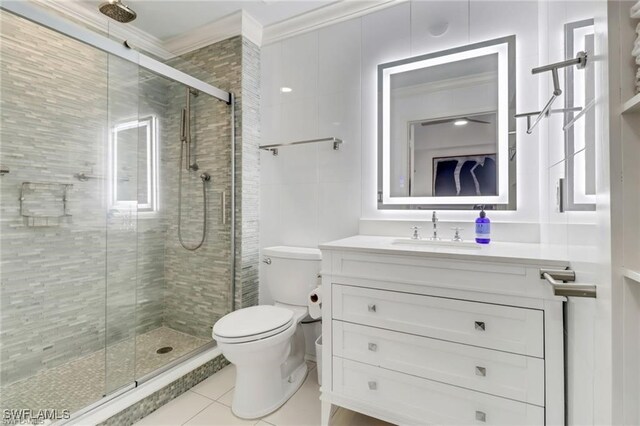 bathroom with tile patterned flooring, vanity, crown molding, a shower with shower door, and toilet