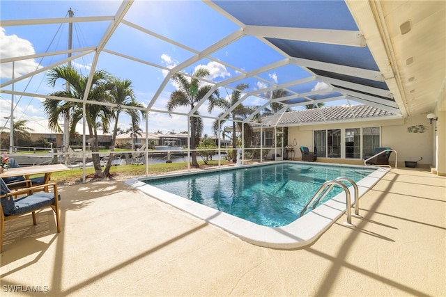 view of pool with glass enclosure and a patio