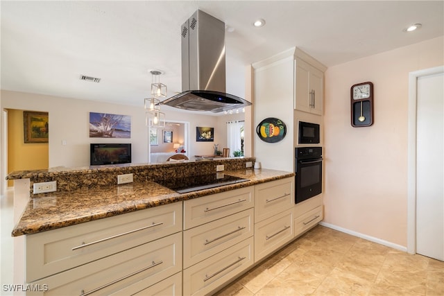 kitchen featuring dark stone countertops, island range hood, black appliances, and kitchen peninsula