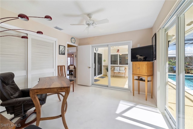 office space with concrete flooring, ceiling fan, and plenty of natural light