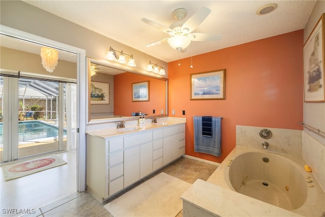 bathroom with tile patterned floors, a tub, a textured ceiling, vanity, and ceiling fan