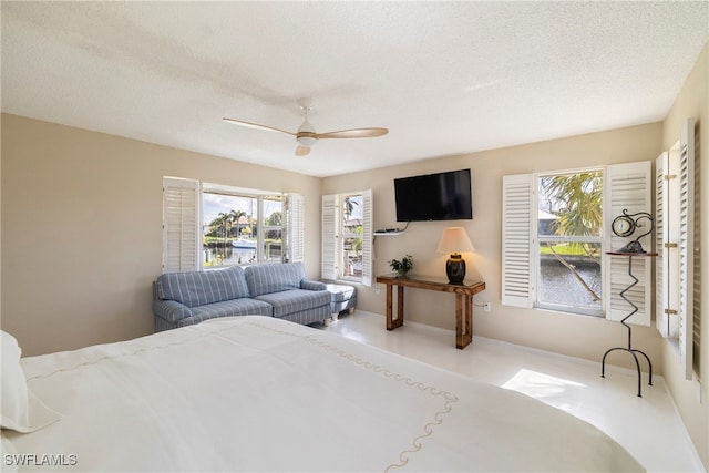 bedroom with ceiling fan, multiple windows, and a textured ceiling