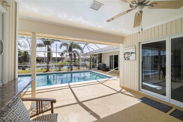 view of pool featuring ceiling fan, glass enclosure, and a patio area