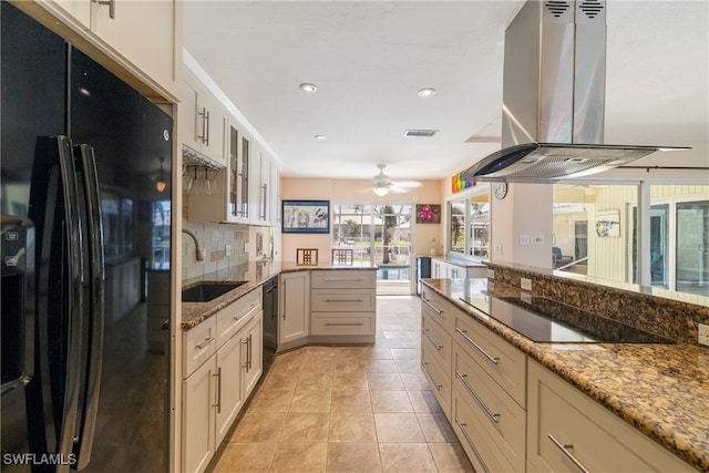 kitchen with sink, black appliances, light stone countertops, ventilation hood, and decorative backsplash