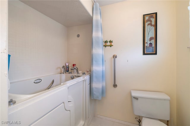 bathroom with a bath, tile patterned floors, and toilet