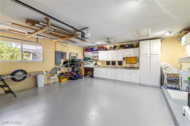 garage with electric panel, ceiling fan, sink, and a garage door opener