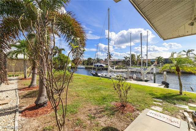 view of dock featuring a lawn and a water view