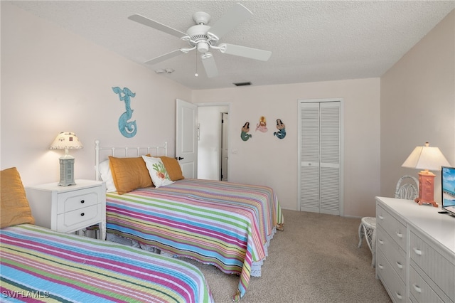 bedroom with a textured ceiling, light carpet, ceiling fan, and a closet