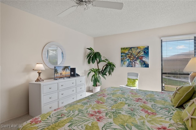 bedroom with ceiling fan, a textured ceiling, and carpet