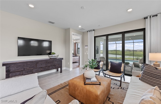 living room featuring light hardwood / wood-style floors and a water view