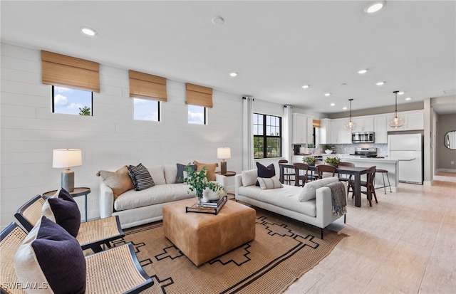 living room with light hardwood / wood-style floors and a healthy amount of sunlight