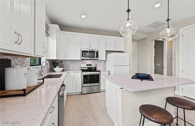 kitchen with a center island, white cabinets, sink, and stainless steel appliances