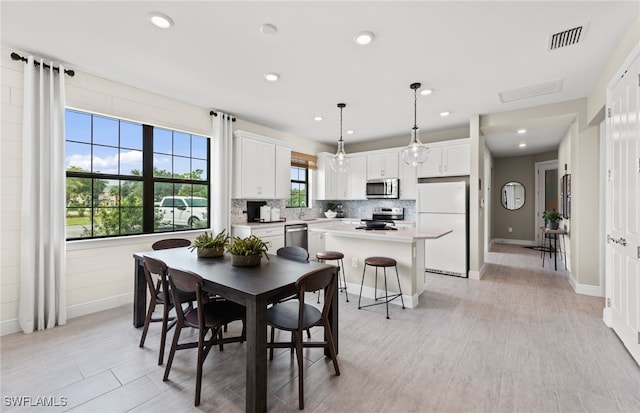 dining area with sink and light hardwood / wood-style floors