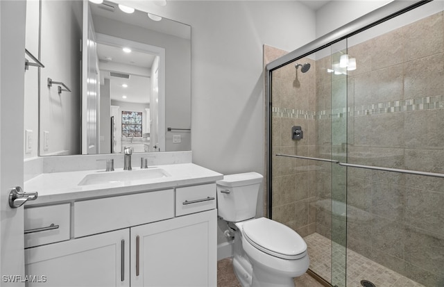 bathroom featuring toilet, vanity, and walk in shower