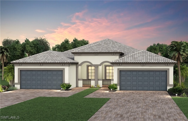 view of front of home with a garage and a lawn