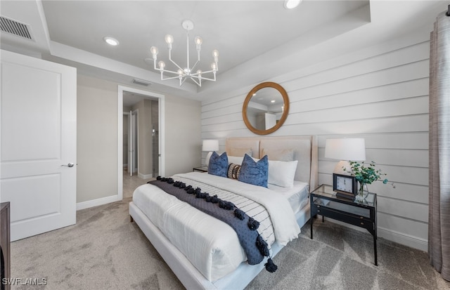 bedroom featuring a tray ceiling, an inviting chandelier, and carpet floors