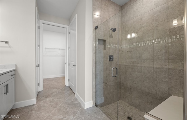 bathroom featuring tile patterned flooring, vanity, and a shower with door